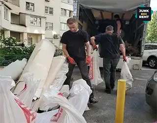 Workers handling waste bags.