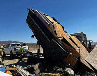 Dump trailer tipping debris.